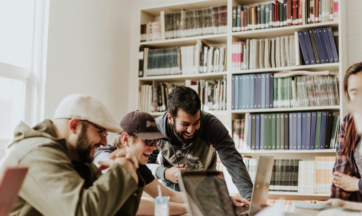 digital marketing agency for a small business: three men laughing while looking in the laptop inside room