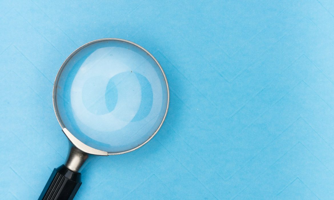 magnifying glass on white table to depict search