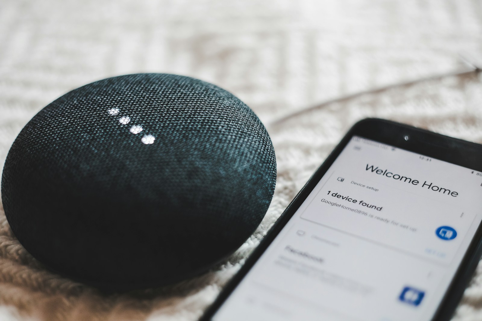 turned-on charcoal Google Home Mini and smartphone: voice search optimization